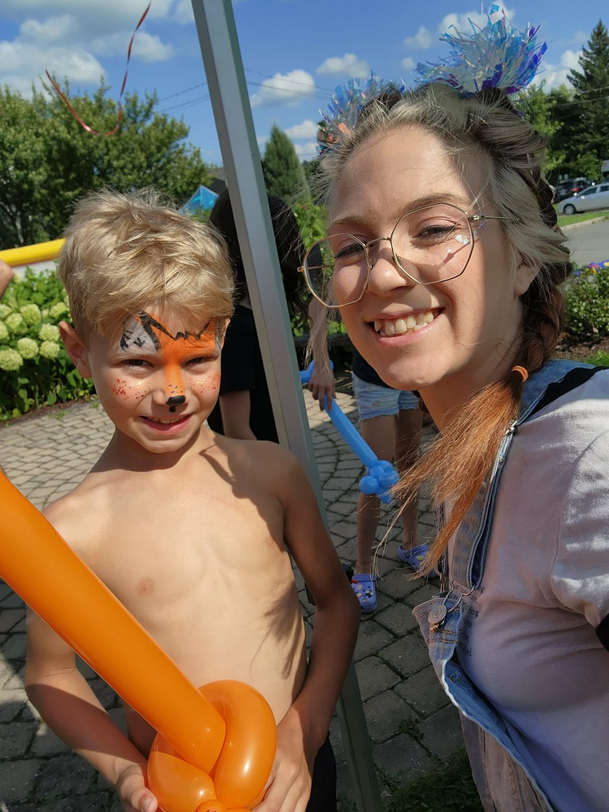 Garçon avec un ballon sculpté et maquillage de renard