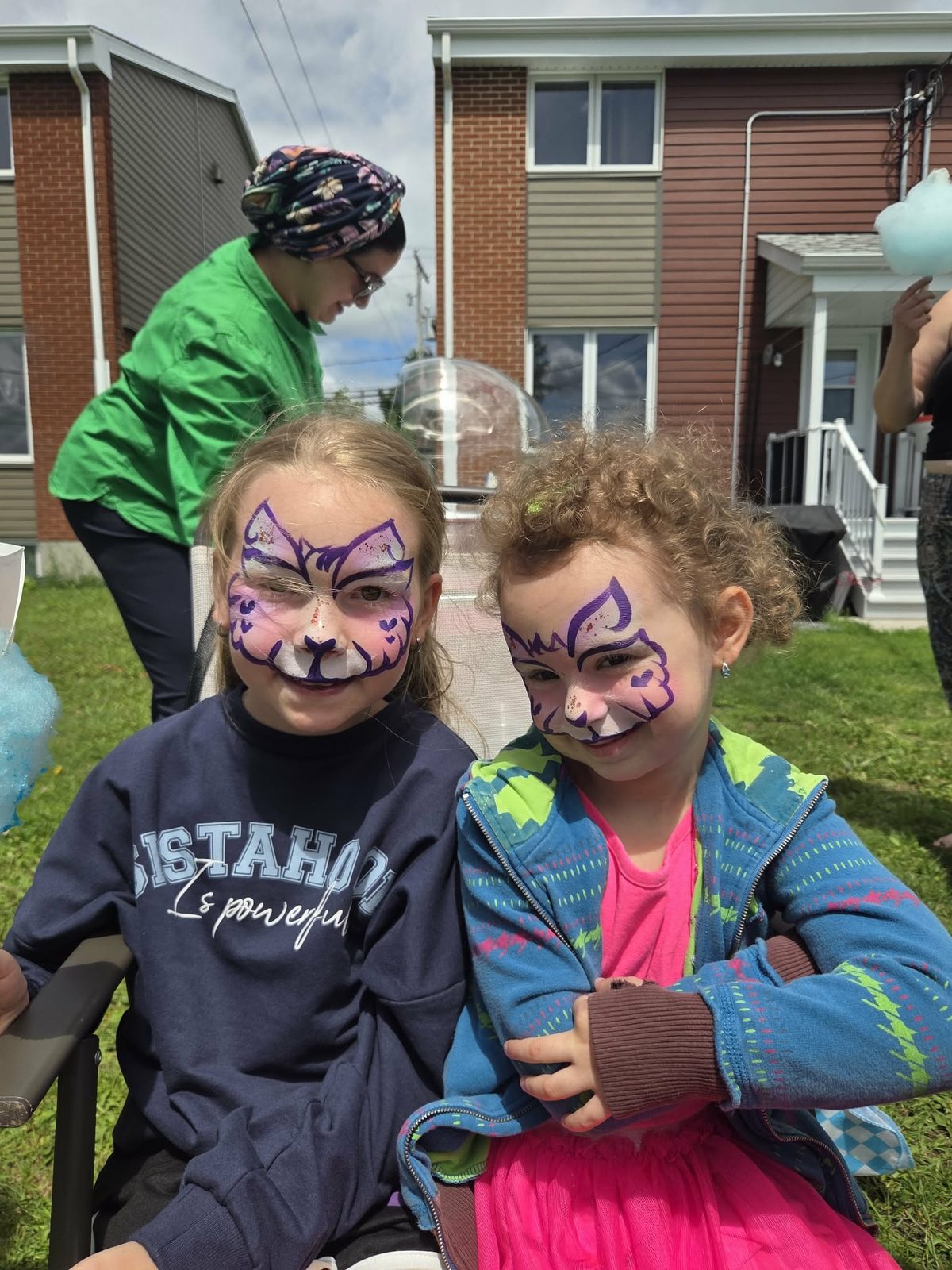 Deux amies maquillées en chats mauves lors d'une fête de quartier