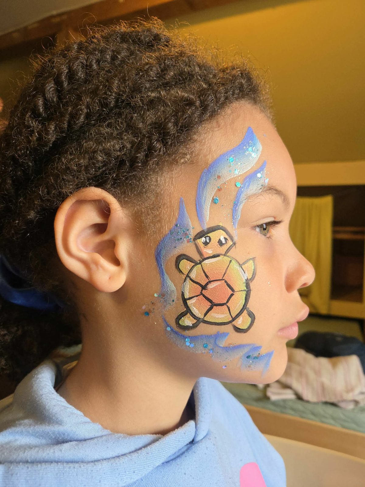 Maquillage d'une tortue de mer avec vagues bleues et paillettes